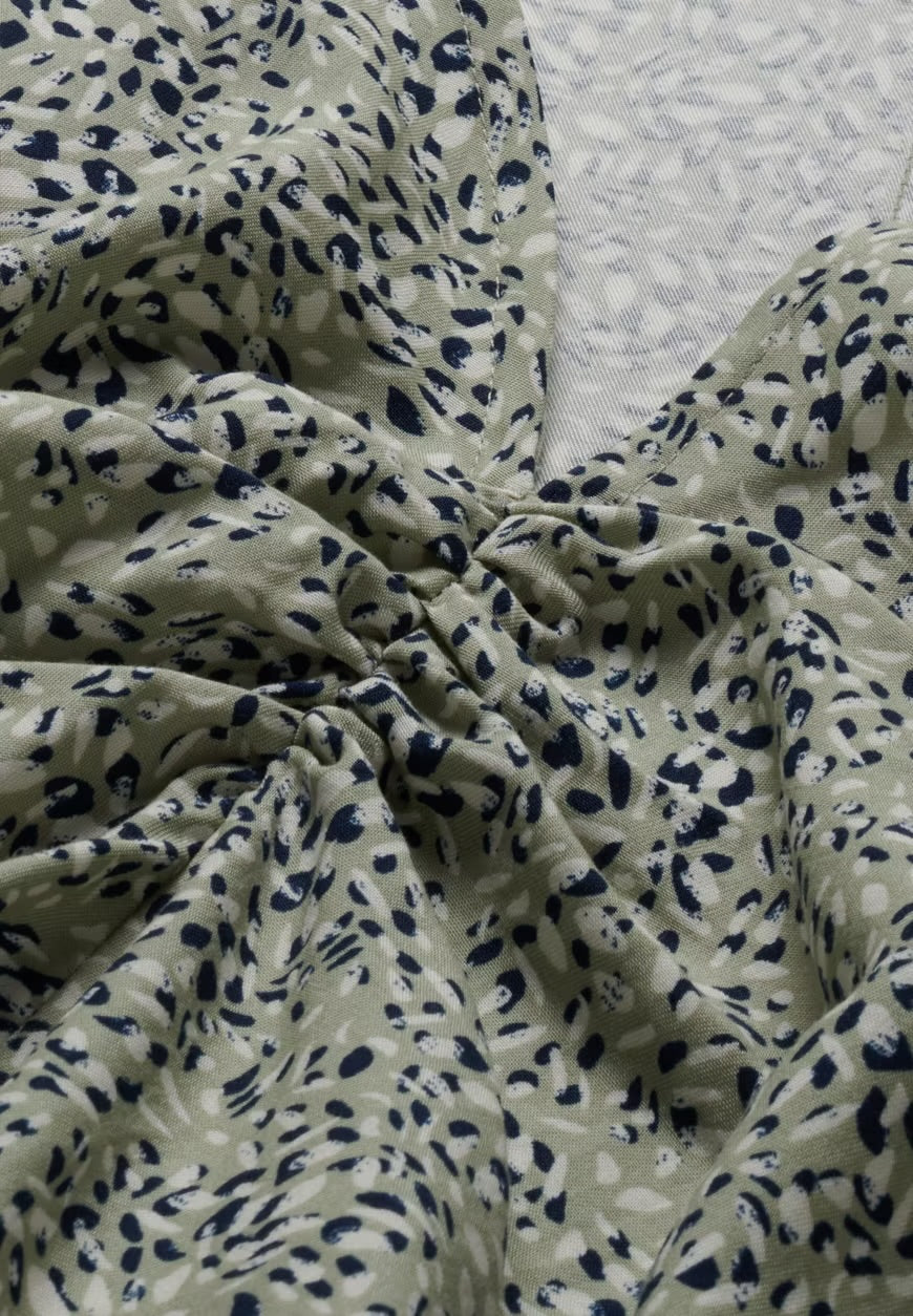 Close-up of the seagreen and navy waterdrop print and gathered detail on the TENCEL™ Lyocell fabric of the ARMEDANGELS Canada Lilaat Waterdrop Dress.