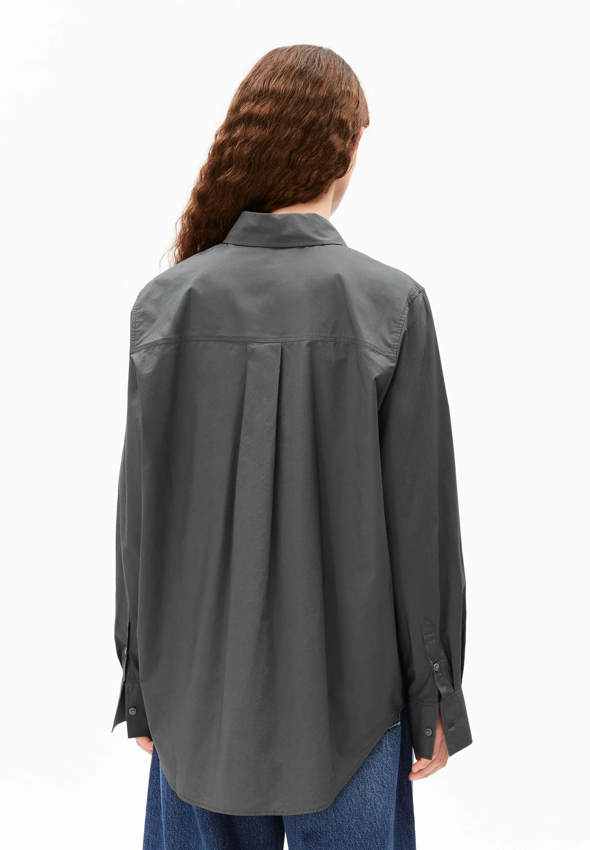 Person wearing a gray shirt from behind on a white background