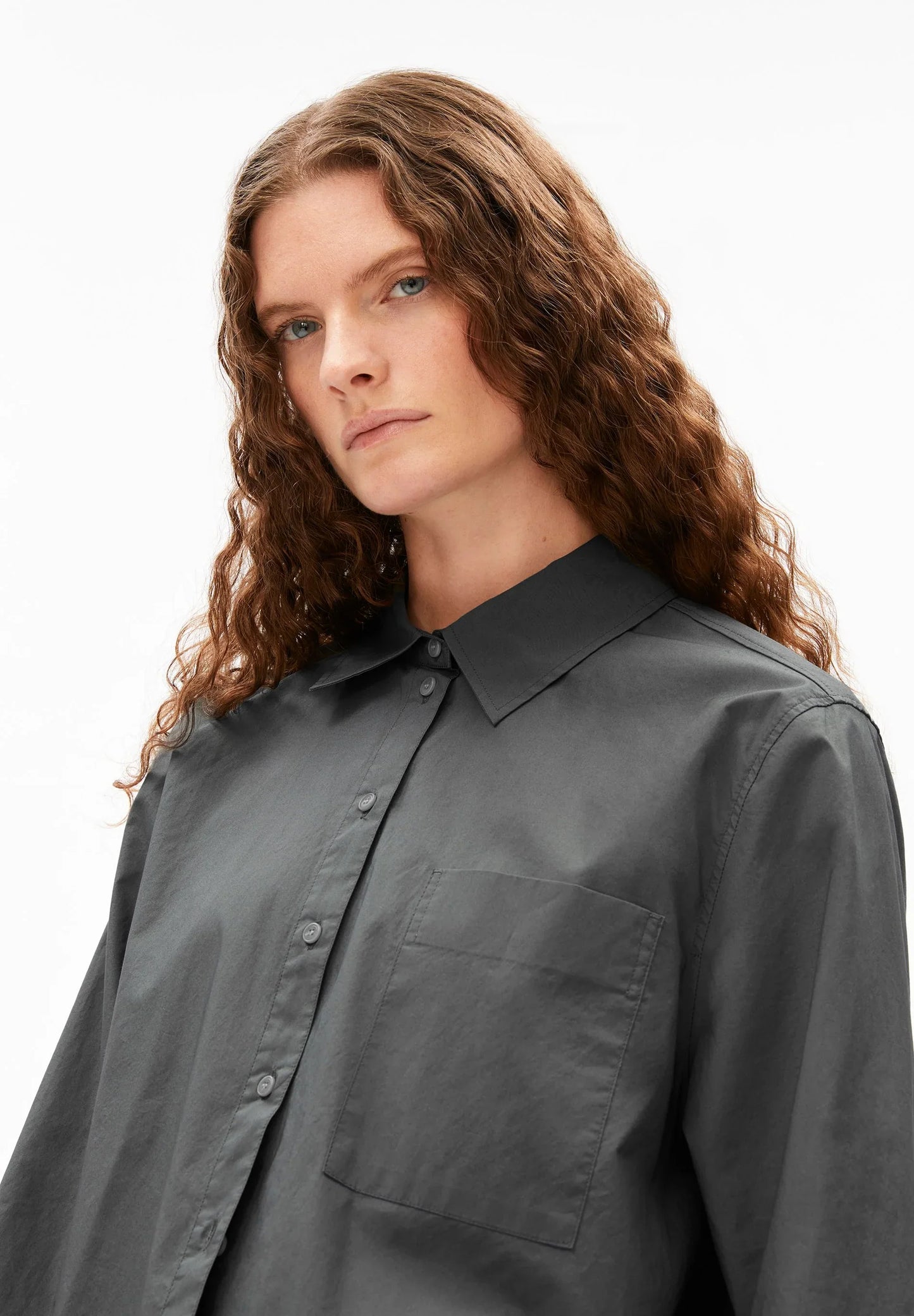 Person wearing a dark gray shirt against a plain background