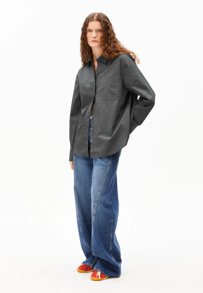 Person wearing a dark gray shirt and blue jeans on a white background