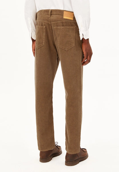 Back view of a man wearing ARMEDANGELS Canada Maakx Cord Trousers in Amberwood, showing the back pockets and waistband patch, against a white background.