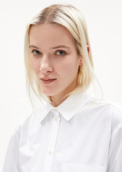 Close-up of the shirt collar and button placket on the ARMEDANGELS Canada Maalgaa Blouse in white, worn by a woman.