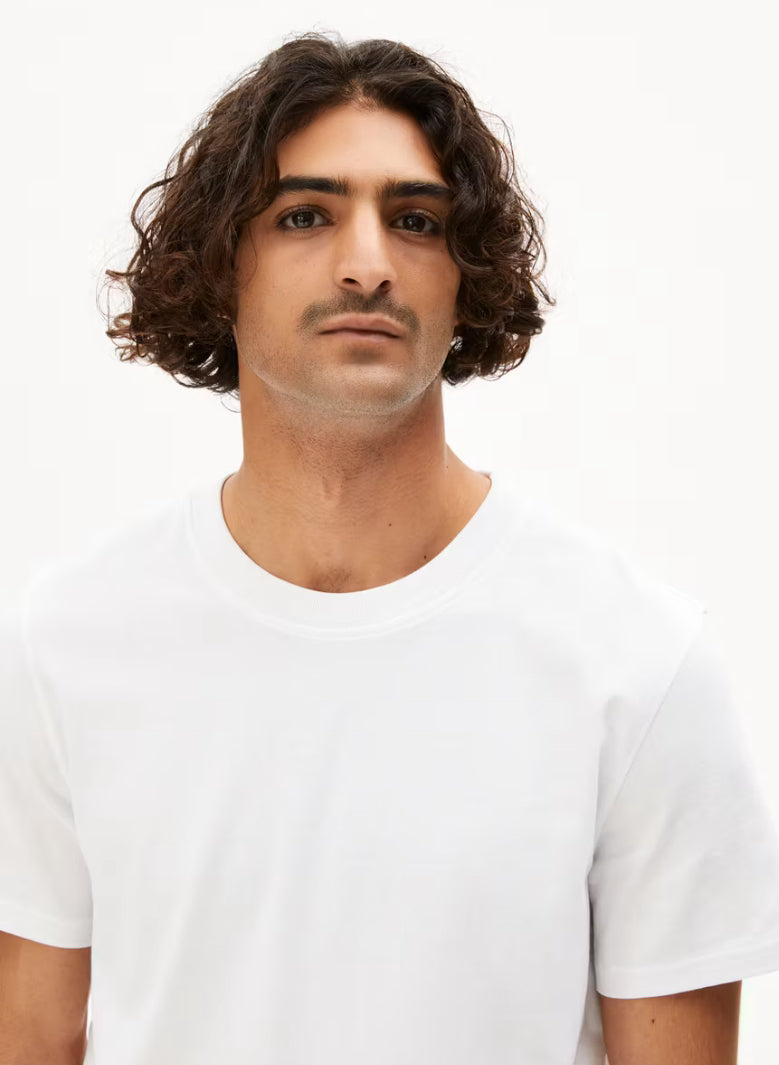 Close-up of the crew neck on the ARMEDANGELS Canada Maarkos Heavy Weight T-Shirt in white, worn by a man.