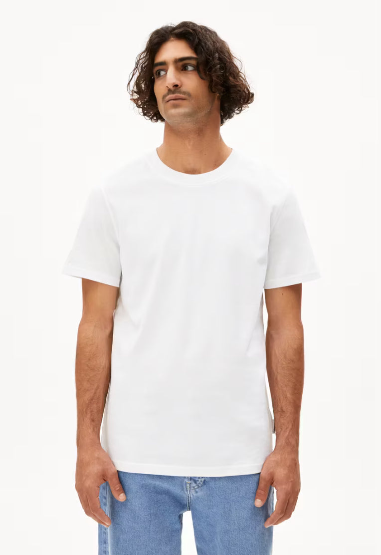 Man wearing the ARMEDANGELS Canada Maarkos Heavy Weight T-Shirt in white with light-wash jeans, front view on a white background.