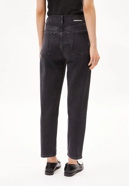 Back view of a woman wearing ARMEDANGELS Canada Mairaa mom jeans in black with loafers on a white background.