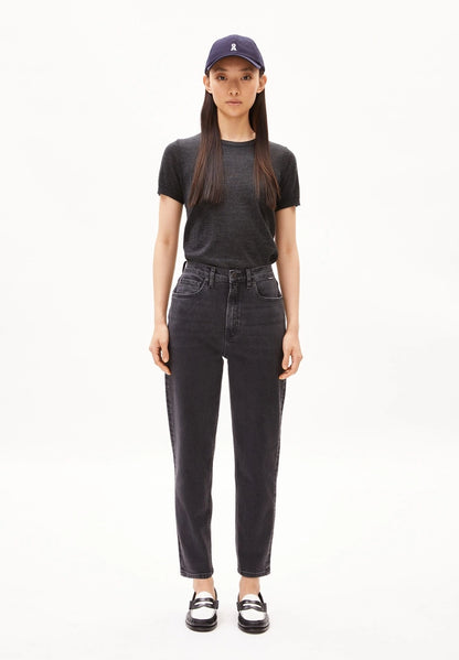 Full-length view of a woman wearing ARMEDANGELS Canada Mairaa high-waist mom jeans in black with a navy cap and grey tee on a white background.