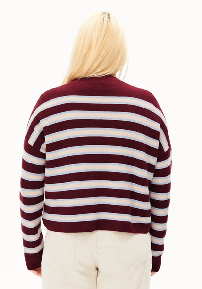 A person viewed from the back wearing a long-sleeve knit sweater with horizontal burgundy and white stripes, paired with light beige pants, against a plain white background.