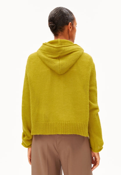 Back view of a woman wearing ARMEDANGELS Canada Mohair-Blend Knitted Hoodie in Mosslace, showing the hood and relaxed fit, against a white background.