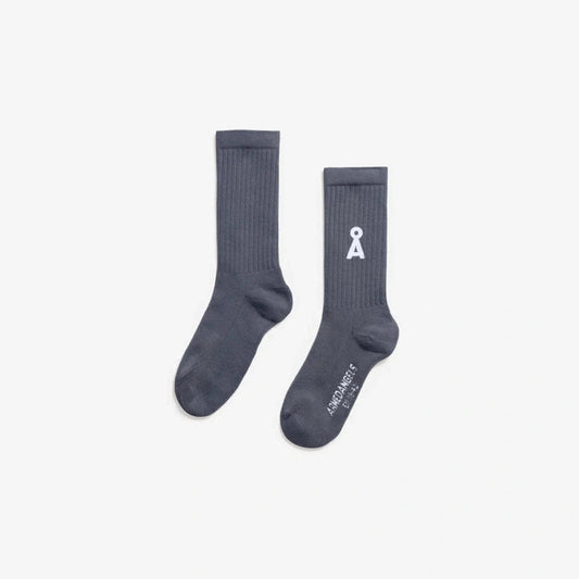 Two light navy socks with a logo on a light gray background