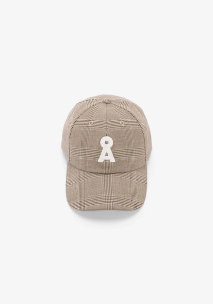 A beige plaid baseball cap featuring a white embroidered patch on the front, set against a plain white background.