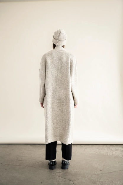 Back view of BodyBag by Jude long textured cream beige knit cardigan with matching beanie and black pants in Kelowna