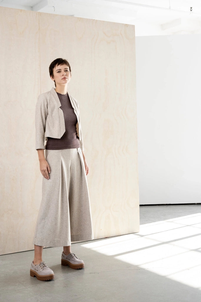 Three-quarter view of the Bodybag by Jude Nassau Jacket in Sand, showing the cropped length and the clean tailored line from shoulder to hem.