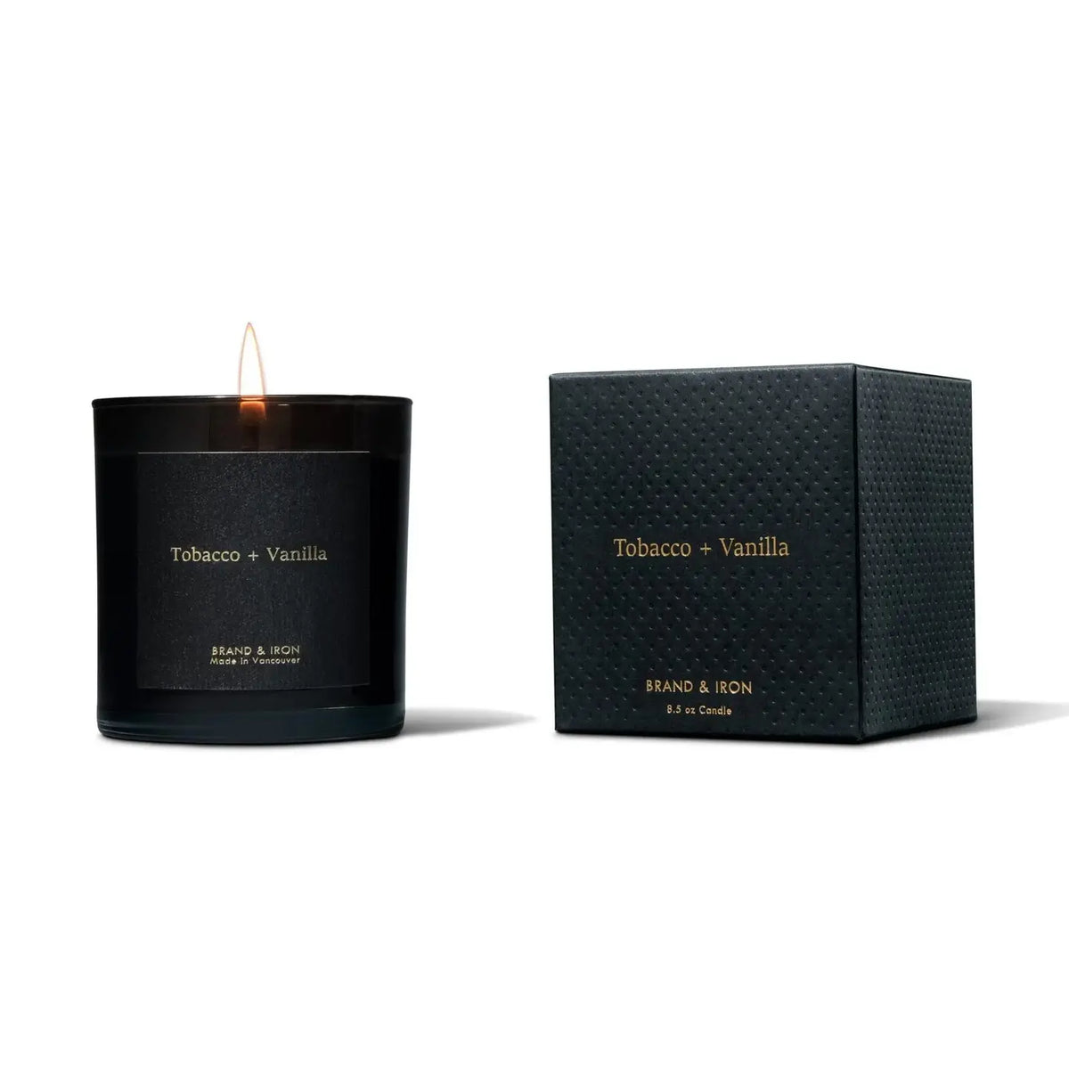 Black candle labeled 'Tobacco + Vanilla' with matching black packaging on a white background