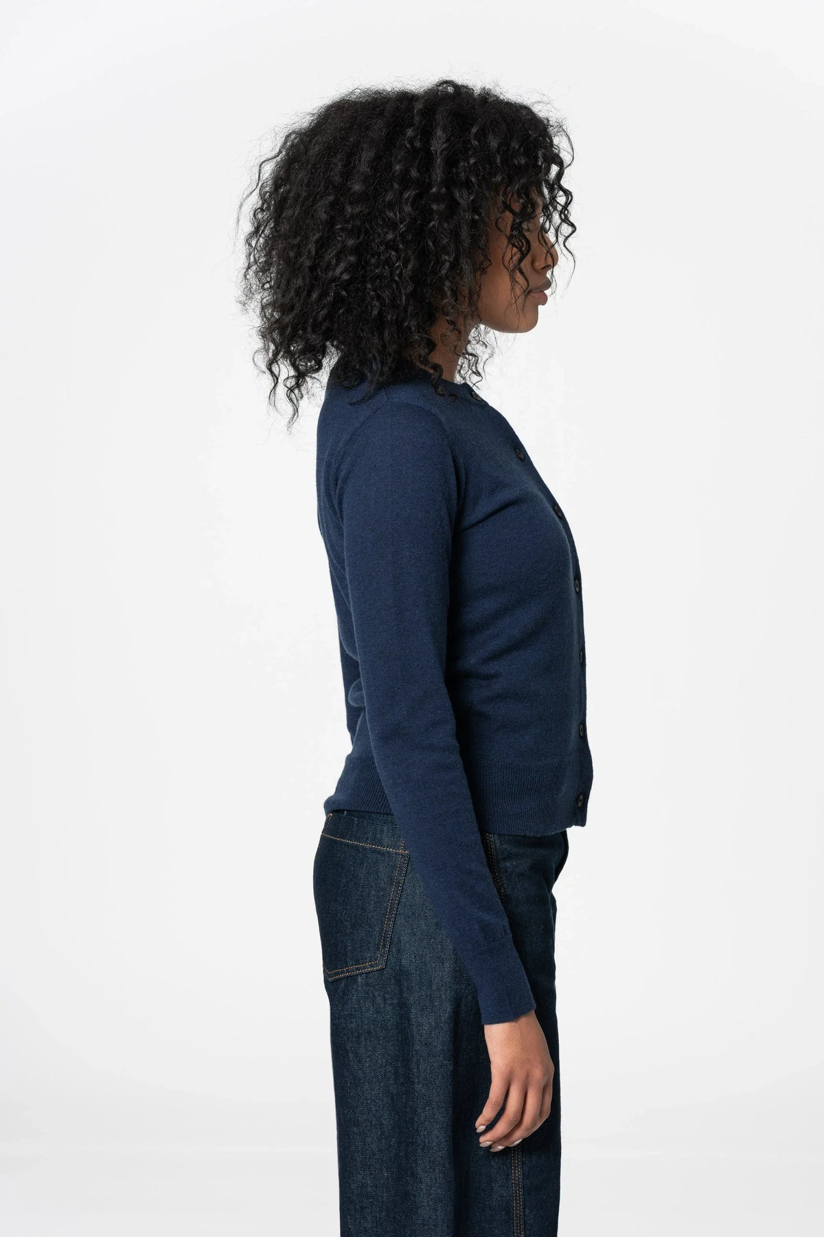 Side view of a woman wearing a Dinadi merino wool cardigan in navy, perfect for layering and comfort in Kelowna