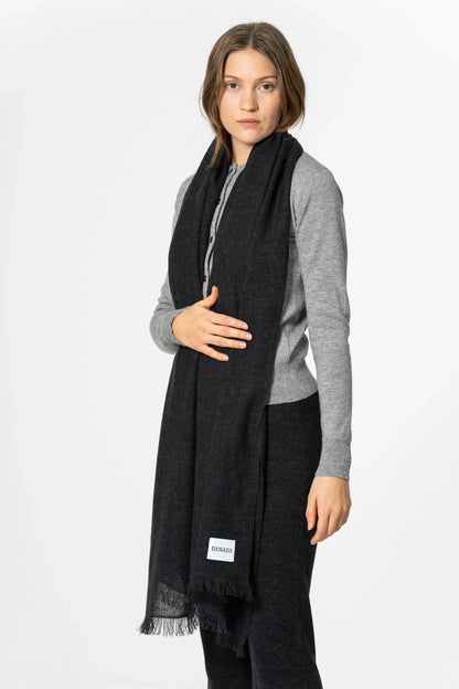Woman wearing a black scarf with a gray shirt on a white background
