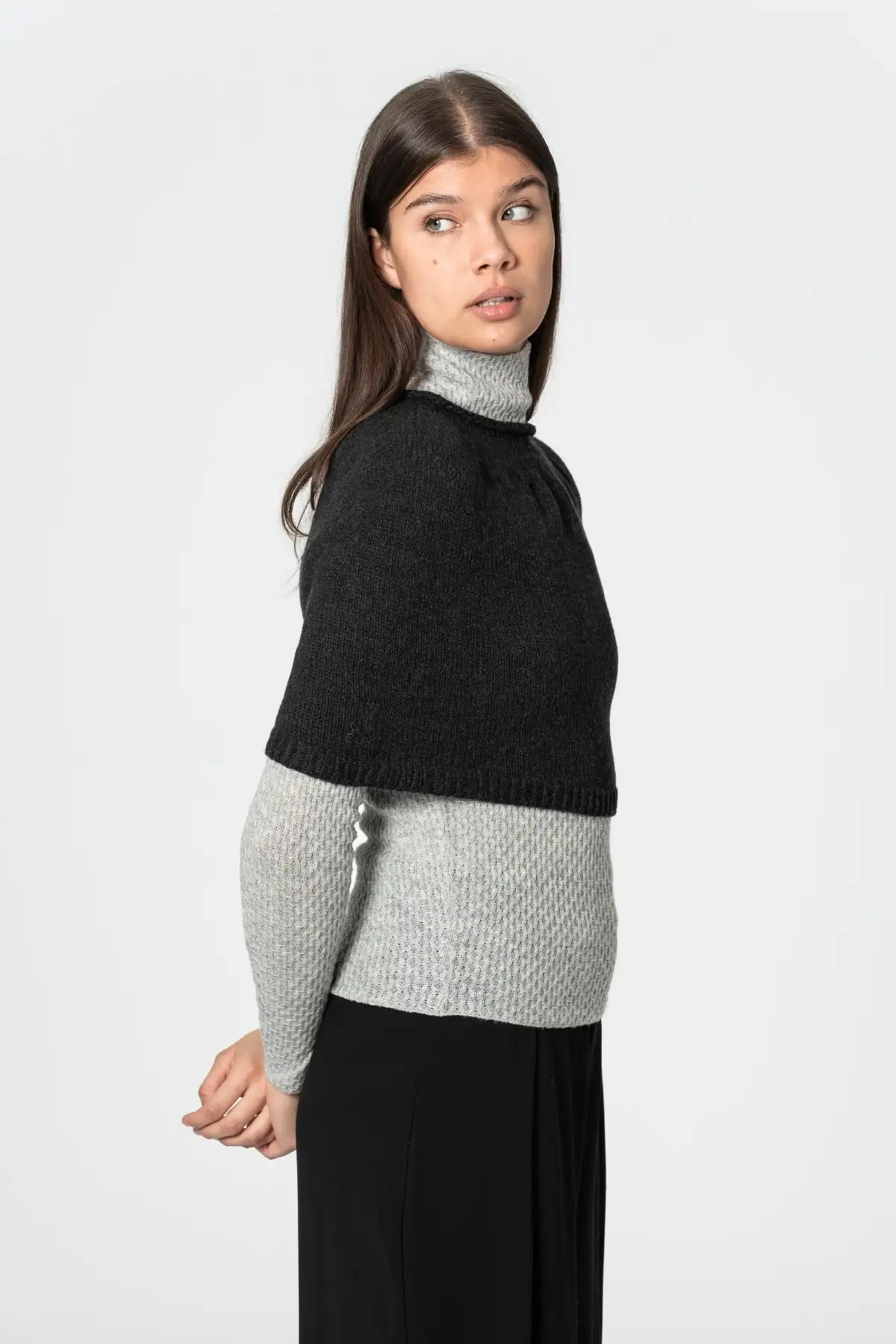 Dinadi black poncho styled over a grey sweater, perfect for layering and warmth in Kelowna and Canada