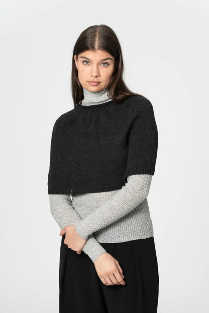 Dinadi black poncho designed for warmth and style, layered over a light turtleneck sweater in Kelowna and Canada