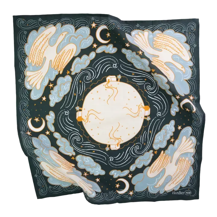 A square silk scarf featuring a celestial design with a central sun, surrounding birds, crescent moons, stars, and zodiac symbols in light blue, cream, and gold on a dark navy background.