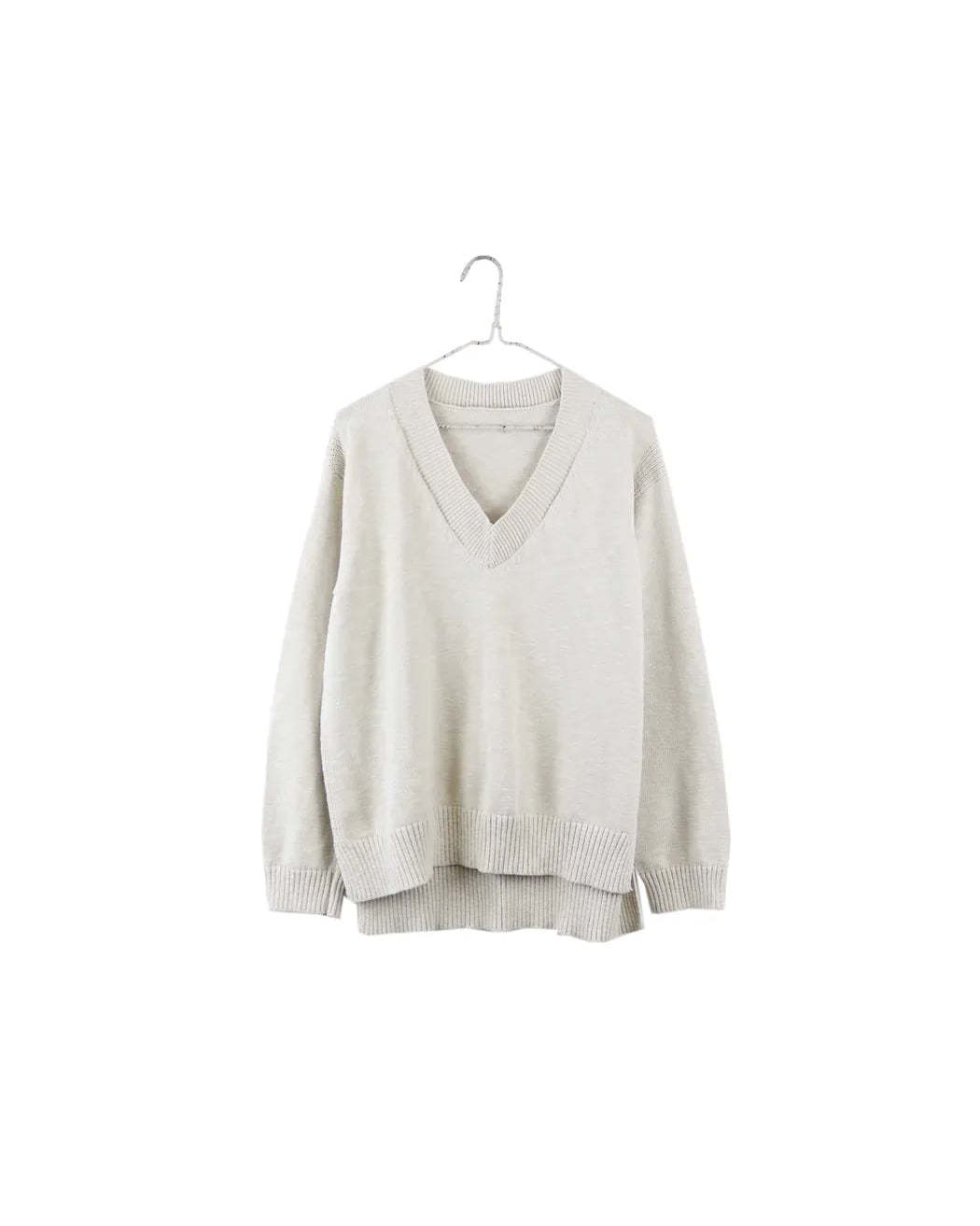 A light beige knit sweater with a V-neck and long sleeves, hanging on a simple metal hanger against a solid white background.