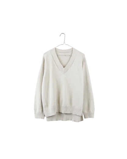 A light beige knit sweater with a V-neck and long sleeves, hanging on a simple metal hanger against a solid white background.