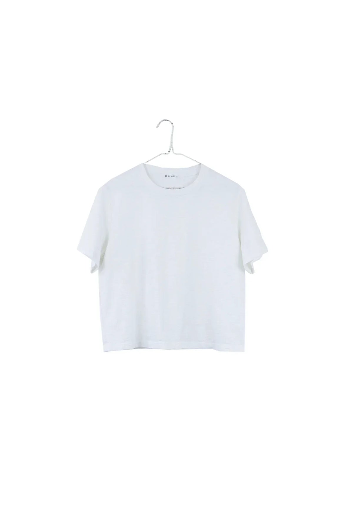 A white short-sleeve cropped T-shirt hanging on a metal hanger against a plain white background.
