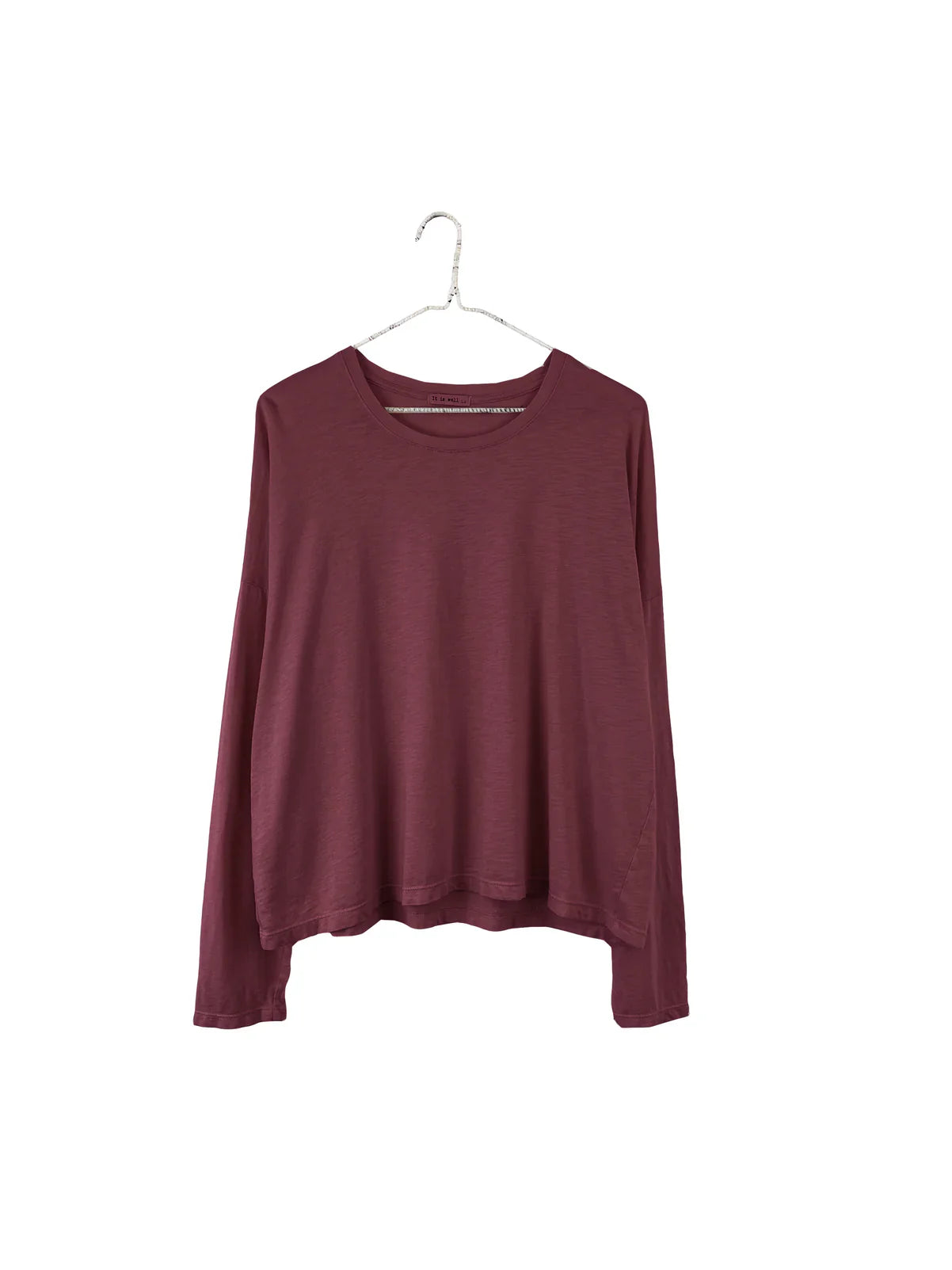 A long-sleeve crewneck top in a deep burgundy or maroon color, hanging on a silver metal hanger against a plain white background.