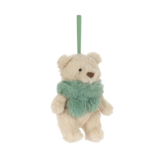 Jellycat Bartholomew Bear Jr. Winter Warmer Decoration at an angle: a small fluffy beige bear with a brown embroidered nose and a sage green faux-fur scarf, hanging from a green ribbon loop.