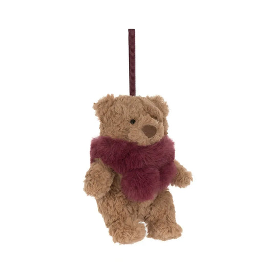 Jellycat Bartholomew Bear Winter Warmer Decoration at an angle: a small fluffy caramel brown bear with an embroidered nose and a burgundy faux-fur scarf, hanging from a burgundy ribbon loop.