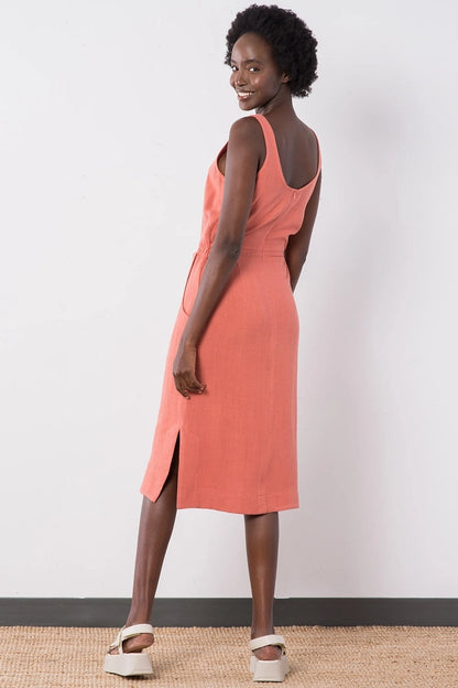 Back view of the Jennifer Glasgow Design Aisha Dress in Terracotta, showing the low scoop back, the back zip and the straight midi skirt with a side slit.