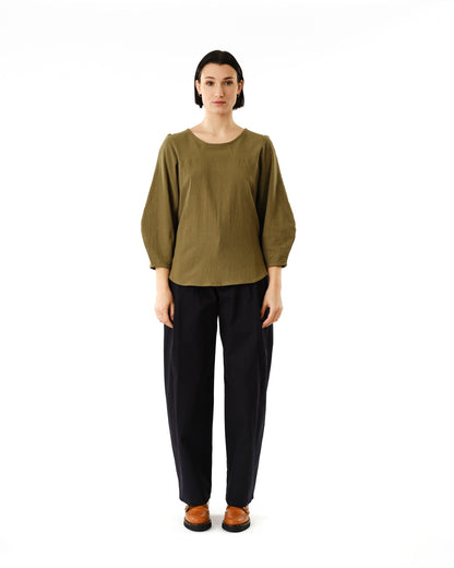 Jennifer Glasgow Design olive green blouse with three quarter puff sleeves paired with black trousers and brown loafers
