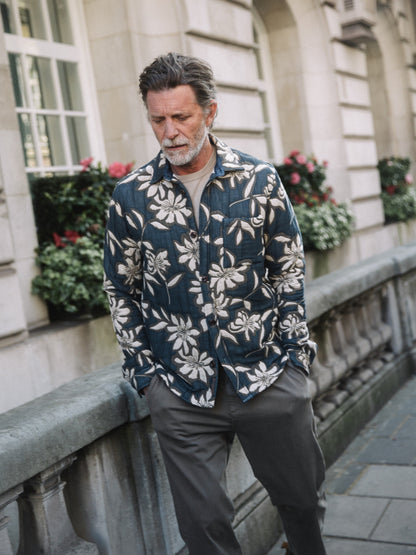 Older man wearing Mos Mosh Gallery vintage indigo overshirt with white floral print over cream tee on city sidewalk in Kelowna
