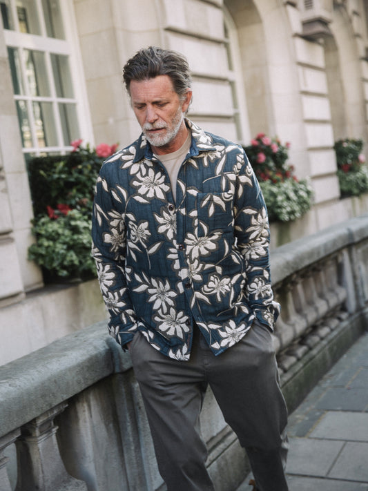 Older man wearing Mos Mosh Gallery vintage indigo overshirt with white floral print over cream tee on city sidewalk in Kelowna