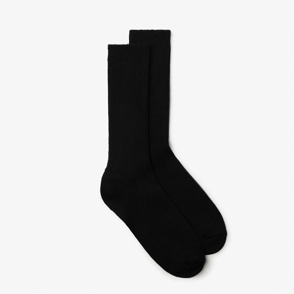 A pair of black crew-length socks displayed flat against a clean, light off-white background.