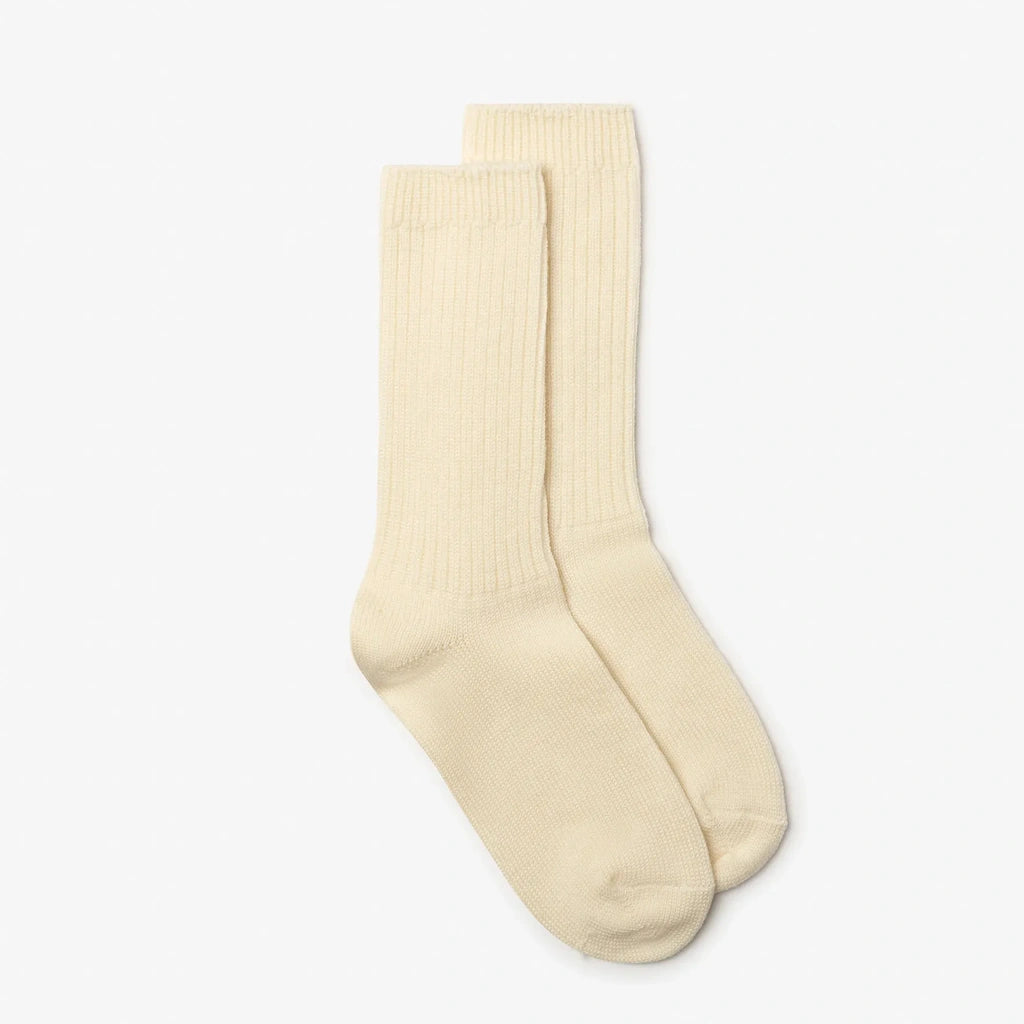A pair of cream-colored ribbed crew socks displayed against a clean, light gray background.