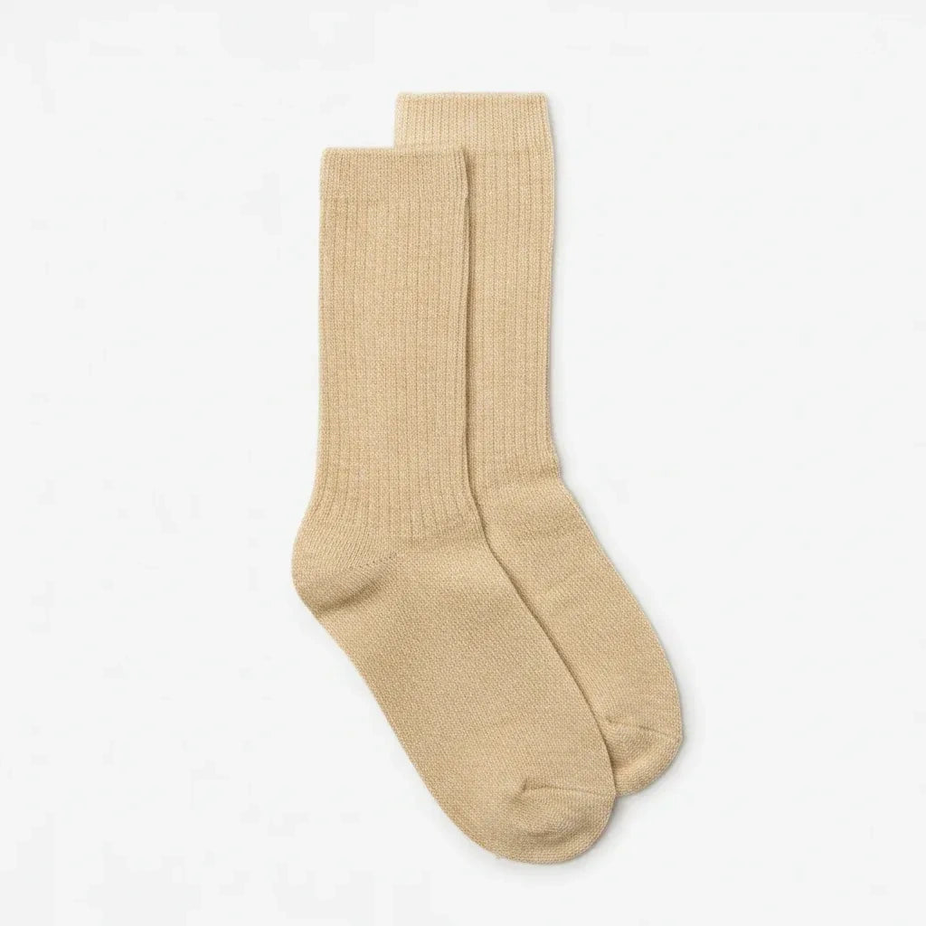 A pair of ribbed crew socks in a light beige color, displayed against a clean, off-white background.