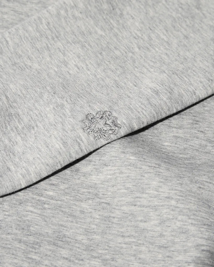 Close-up of the MOS MOSH Gallery Canada Abel Crew Neck Sweat in grey melange, showing the soft heathered fabric and the tonal embroidered logo on the sleeve.