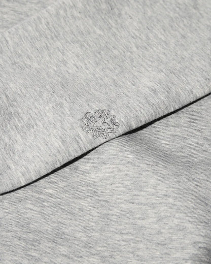 Close-up of the MOS MOSH Gallery Canada Abel Crew Neck Sweat in grey melange, showing the soft heathered fabric and the tonal embroidered logo on the sleeve.