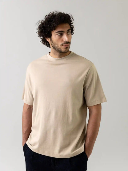 Mos Mosh Gallery beige oversized crew neck t-shirt on male model looking sideways with hands in pockets in Kelowna