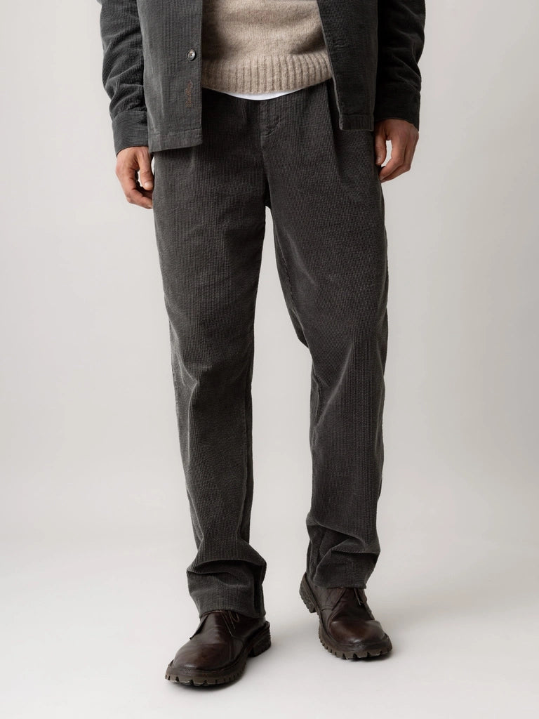 Front view of MOS MOSH Gallery Canada Conor Corduroy Pant in Castlerock from the waist down, worn with brown leather boots, against a light grey background.