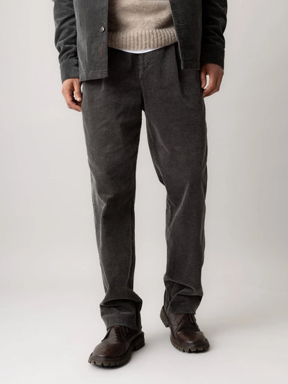Front view of MOS MOSH Gallery Canada Conor Corduroy Pant in Castlerock from the waist down, worn with brown leather boots, against a light grey background.