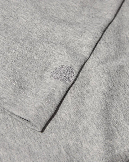Close-up of the MOS MOSH Gallery Canada Darren Tee in grey melange, showing the soft cotton jersey and the tonal embroidered logo on the sleeve.
