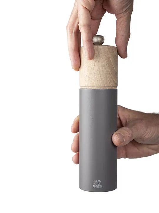 Peugeot BOREAL Pepper mill in Rock Grey, with hand twisting the top to grind the pepper