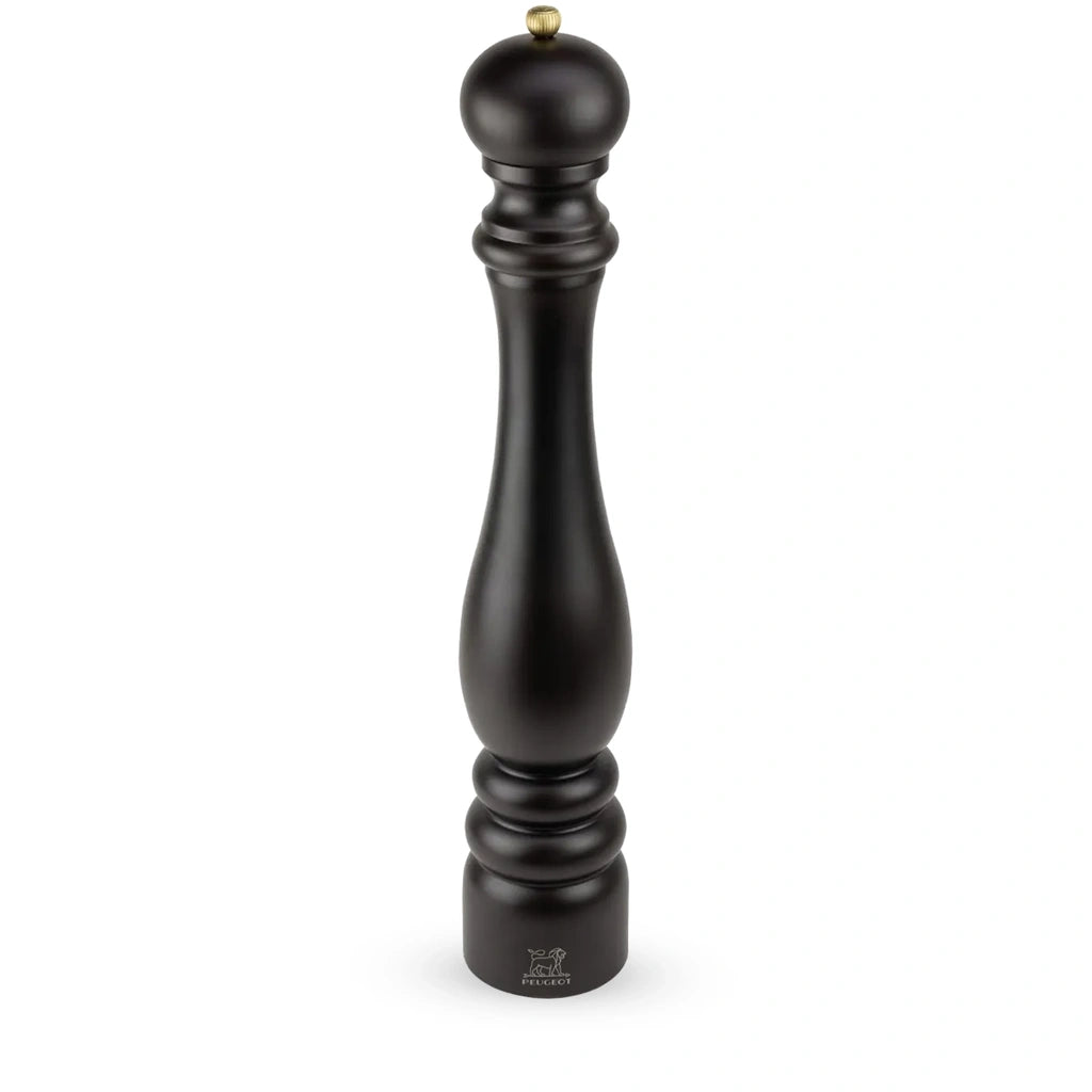 A tall black pepper mill with a small gold-toned metal knob on top, shown against a plain white background.