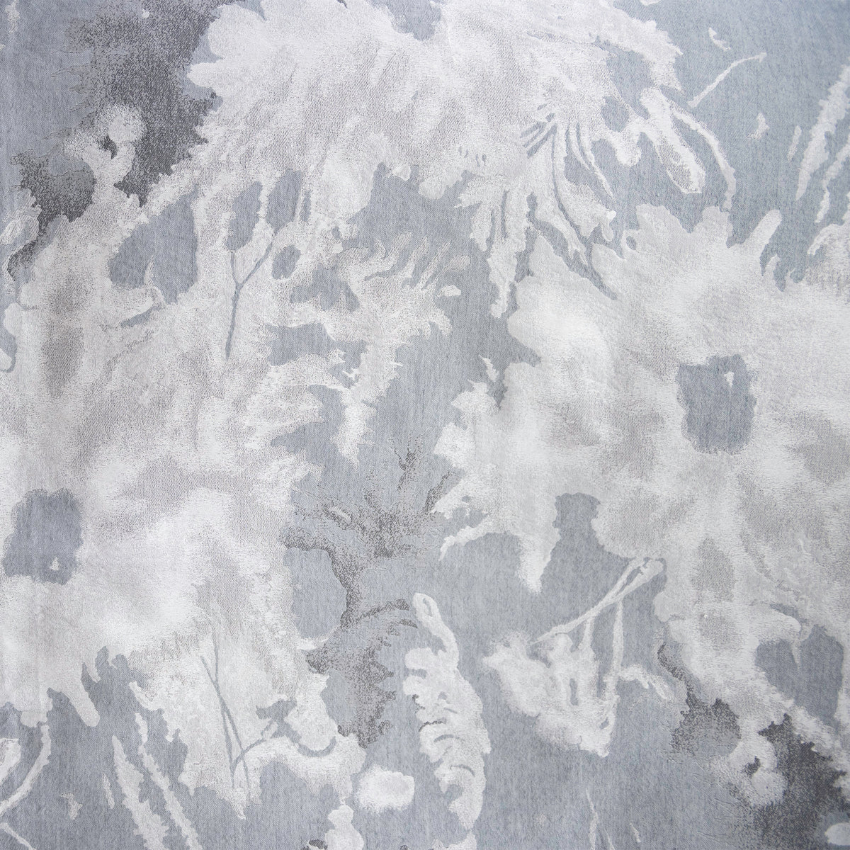 Close-up swatch of the Blossom jacquard in Moonlight, with pale silvery blooms over a cool grey-blue ground.