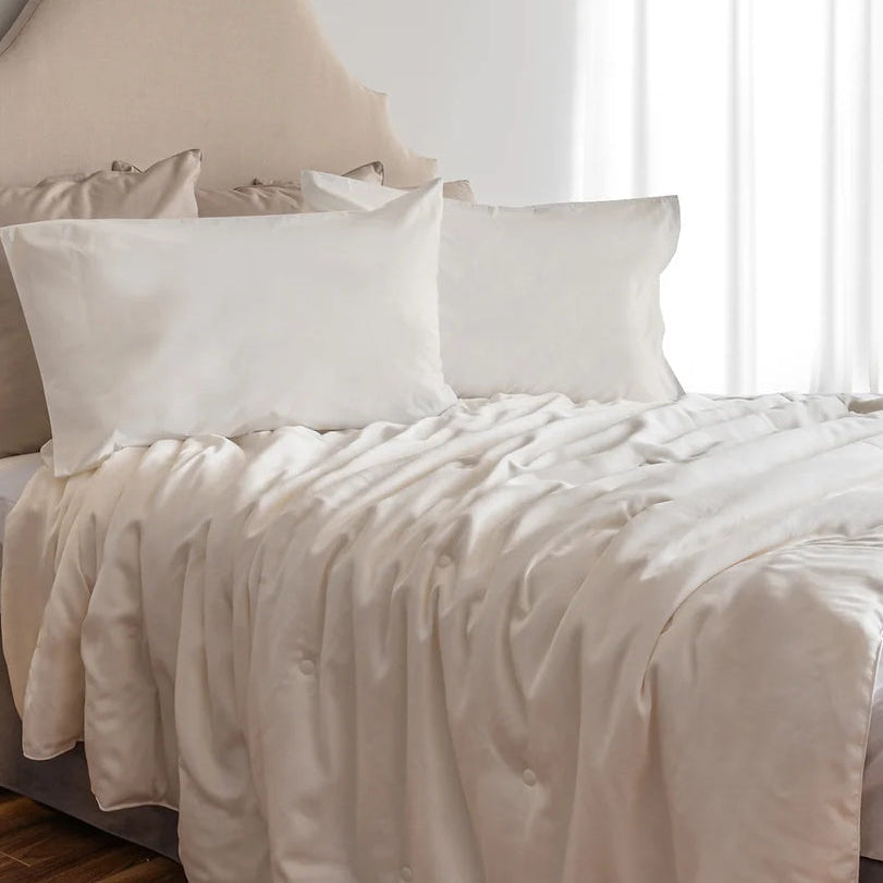 A white premium silk duvet cover with a 300 thread count lyocell sateen texture, displayed on a bed with two pillows.
